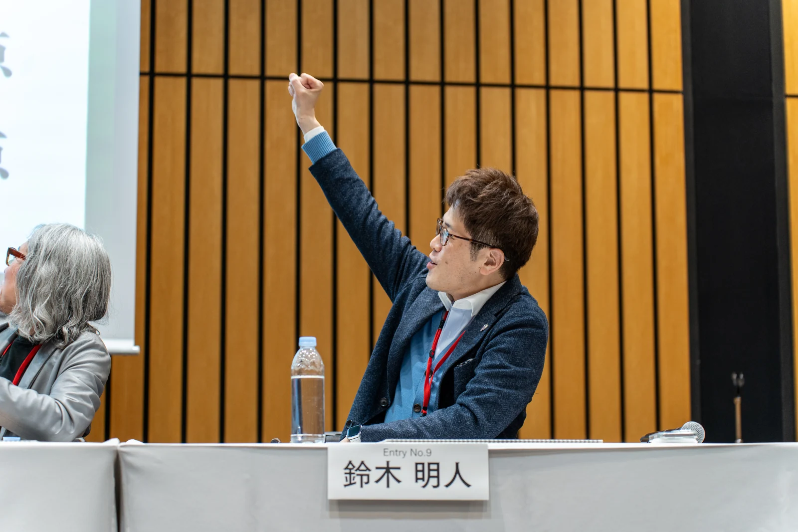 会場で腕を上げる出場者